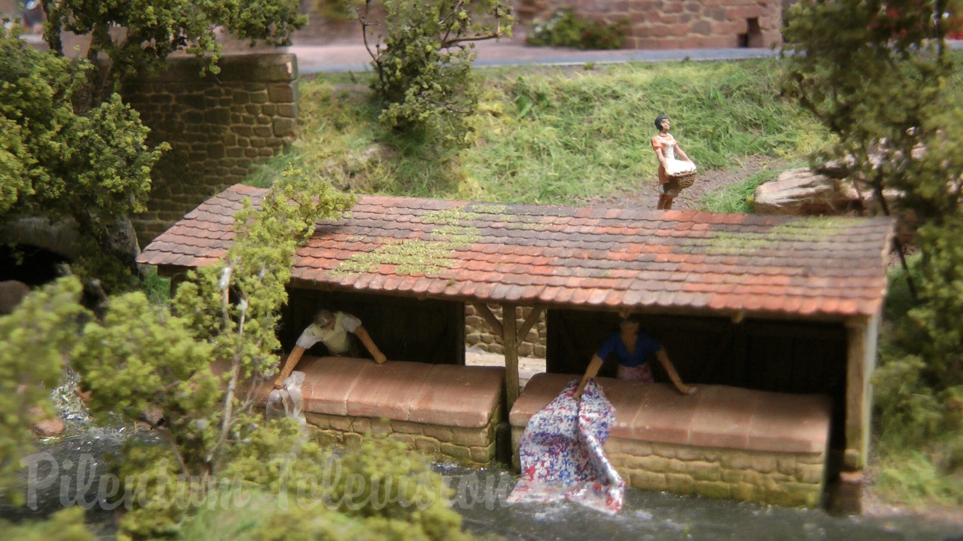 The little steam train inside a realistic built model railway landscape in HO scale