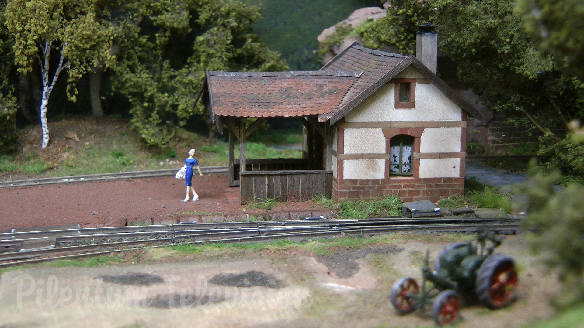 The little steam train inside a realistic built model railway landscape in HO scale