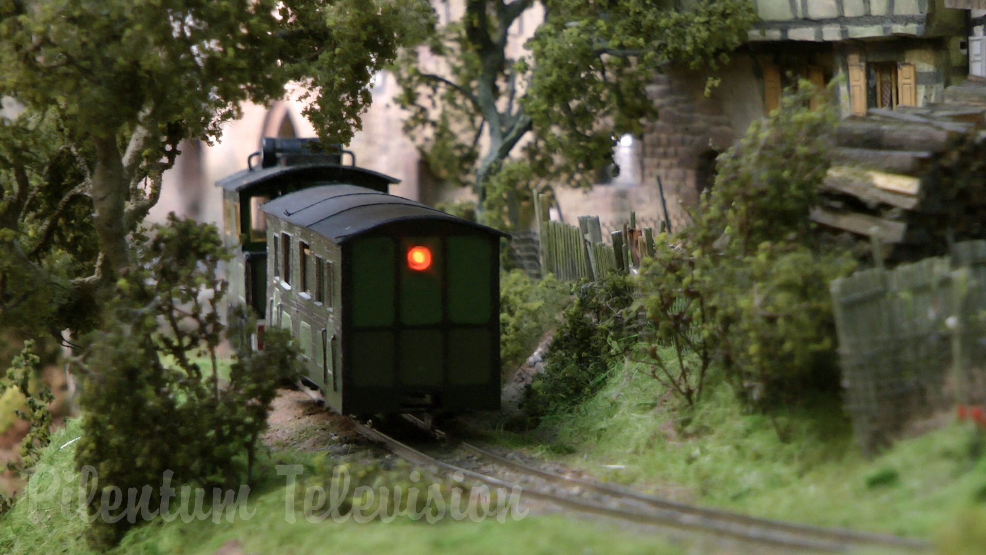 The little steam train inside a realistic built model railway landscape in HO scale